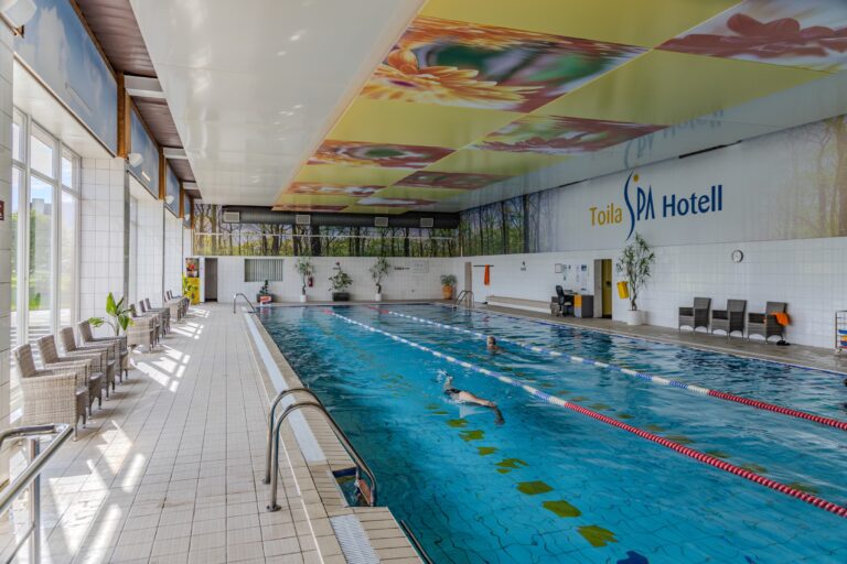 Toila Spa lap pool with lane ropes, the Toila Spa Hotel logo on the wall and a swimmer in the water