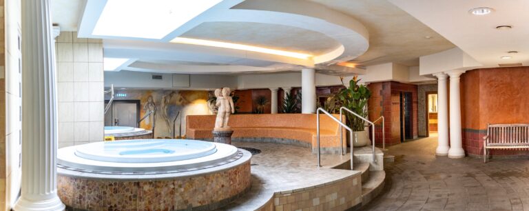 A round whirlpool with white columns and a sculpture in the Toila Spa sauna centre, panorama