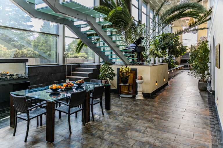 Toila Spa winter garden: a dining table, palms, a staircase with glass steps and a piano