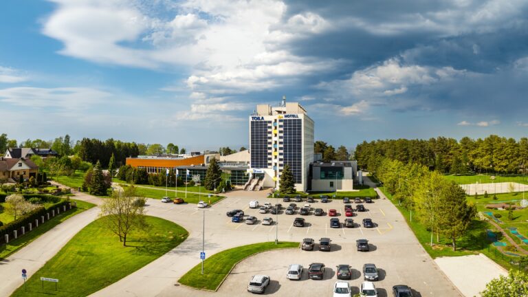 Отель Toila Spa, большая парковка и окружающий парк под драматичными облаками, широкая панорама с дрона