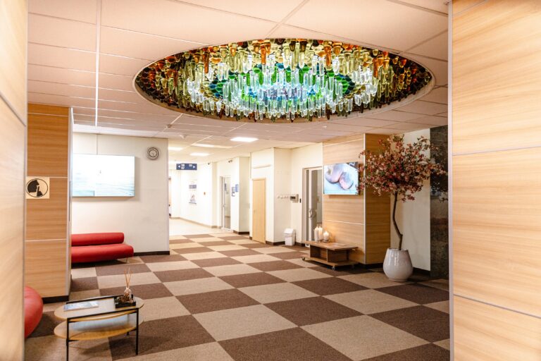 Toila Spa lobby: a round ceiling light of coloured glass, a chequered floor and a red sofa