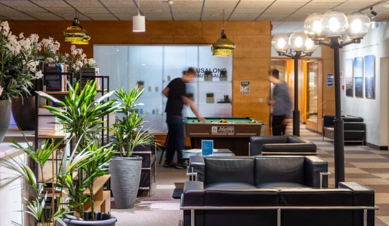 A lounge at Toila Spa: leather sofas, house plants and a pool table with two guests playing