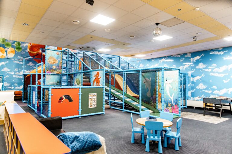 Toila Spa children's playroom: a blue climbing frame with a slide, a small table and chairs